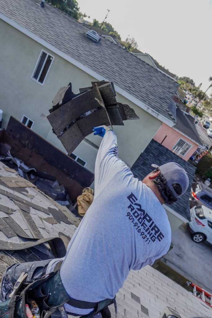 Licensed Victorville roofer installing asphalt shingles with pneumatic nailer on residential home