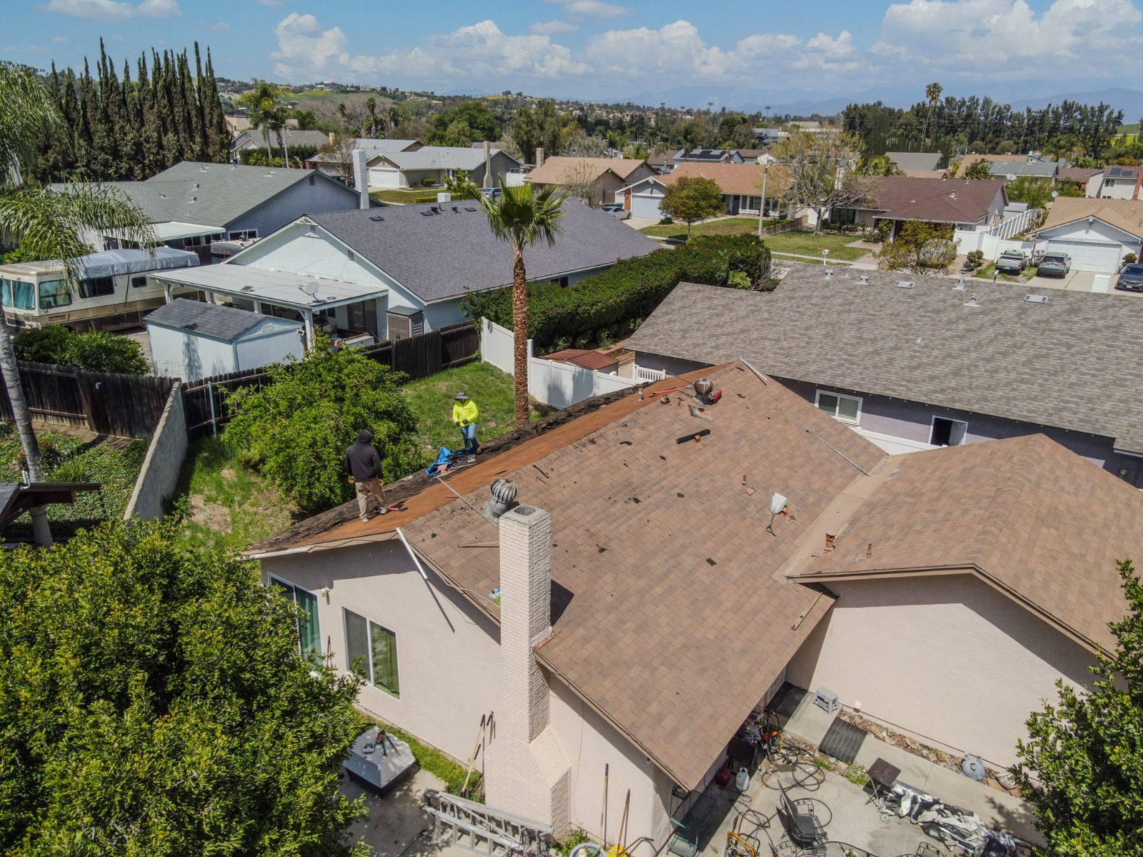 Roof repair technician fixing storm-damaged shingles to stop active roof leak